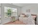 Sunlit bedroom with a large window and window blinds, complemented by a comfortable daybed at 410 Apex Cir, Shelby, NC 28152