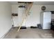Spacious garage with attic access, shelving, and a utility refrigerator at 410 Apex Cir, Shelby, NC 28152