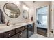 Modern bathroom with double vanity, dark wood cabinets, round mirrors, and a view into the bedroom at 4107 Park South Station Blvd, Charlotte, NC 28210
