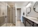 Bathroom featuring a glass-enclosed shower, double sinks, and neutral tile at 4107 Park South Station Blvd, Charlotte, NC 28210