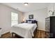 Bedroom features wood floors, a window, and is decorated with blue pillows and a dresser at 4107 Park South Station Blvd, Charlotte, NC 28210