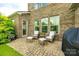 Cozy brick back patio with wicker furniture and view of lush yard, perfect for outdoor entertaining at 4220 Thames Cir, Fort Mill, SC 29715