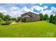 Expansive, lush backyard showcases a well-maintained lawn, landscaping, brick patio, and charming brick home at 4220 Thames Cir, Fort Mill, SC 29715