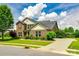 Charming brick two-story home with a lush green lawn and well-maintained landscaping on a sunny day at 4220 Thames Cir, Fort Mill, SC 29715
