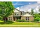 Inviting two-story brick home featuring a well-manicured lawn, mature tree, and charming front porch at 4220 Thames Cir, Fort Mill, SC 29715