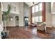 Bright living room with high ceilings, a stone fireplace, and large windows with flowing curtains at 4220 Thames Cir, Fort Mill, SC 29715
