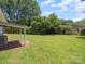 Wide, grassy backyard featuring partial covered patio with AC unit at 427 E 12Th Ave, Gastonia, NC 28054