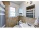 Tiled bathroom featuring a toilet, sink, storage cabinet, and window with natural light at 528 Wakefield Dr # A, Charlotte, NC 28209
