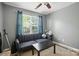 Bedroom boasts a ceiling fan, window with blue curtains, and a cozy blue sofa at 529 River Park Rd, Belmont, NC 28012
