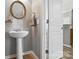 Stylish powder room featuring a pedestal sink, decorative mirror, and neutral decor at 529 River Park Rd, Belmont, NC 28012