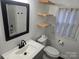 Bathroom with modern fixtures, wood shelves, new vanity and a black framed mirror at 616 Laurel St, Albemarle, NC 28001