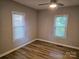 Cozy bedroom with two windows, neutral walls, updated ceiling fan and wood-look flooring at 616 Laurel St, Albemarle, NC 28001