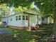 Charming home with brick foundation, front porch, white siding, shed, and well-kept lawn at 616 Laurel St, Albemarle, NC 28001