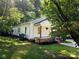 Charming home with lush green lawn, mature trees, and a cozy front porch with brick accents at 616 Laurel St, Albemarle, NC 28001