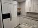 Modern kitchen with white cabinets, granite countertops, stainless steel refrigerator, and microwave at 616 Laurel St, Albemarle, NC 28001