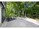Outdoor patio with seating area, firepit, and lush green trees providing a serene and inviting backyard space at 6733 Candlewood Dr, Charlotte, NC 28210