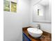 Half bathroom with modern floating sink, stylish fixtures, wood counter, and natural light from small window at 6733 Candlewood Dr, Charlotte, NC 28210