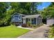 The blue split-level home boasts a well-maintained yard, mature trees, and updated landscaping at 6733 Candlewood Dr, Charlotte, NC 28210