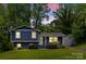 Charming blue two-story home with white trim, surrounded by mature trees and landscaped front yard at 6733 Candlewood Dr, Charlotte, NC 28210