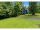 Charming blue two-story home nestled on a lush green lot, surrounded by mature trees and landscaping at 6733 Candlewood Dr, Charlotte, NC 28210