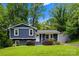 Charming blue split-level home with a well-manicured lawn, lush landscaping, and a welcoming front entrance at 6733 Candlewood Dr, Charlotte, NC 28210