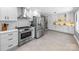 Bright kitchen with stainless steel appliances, white cabinets, tile flooring, and a view into the dining area at 6733 Candlewood Dr, Charlotte, NC 28210
