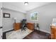 Well-lit home office with hardwood floors, neutral paint, and a traditional wooden desk facing a window at 6733 Candlewood Dr, Charlotte, NC 28210