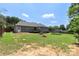 Spacious backyard with green grass, mature trees, a fire pit, and a trampoline at 7627 Sarah Dr, Denver, NC 28037