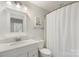 All-white bathroom with a vanity, a framed mirror, and a shower with a curtain at 7627 Sarah Dr, Denver, NC 28037