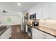 Bright kitchen features stainless steel appliances, white cabinets, and barstool seating at 7627 Sarah Dr, Denver, NC 28037