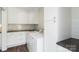 Clean laundry room features stainless steel appliances, white cabinets, and dark countertops at 7627 Sarah Dr, Denver, NC 28037