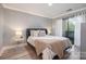 This primary bedroom has wood floors, a queen bed, neutral paint, and access to a balcony at 8135 Cedar Glen Dr, Charlotte, NC 28212