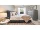 This primary bedroom features wood floors, a queen bed, a neutral color palette and a gray dresser at 8135 Cedar Glen Dr, Charlotte, NC 28212