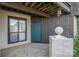 Condo entrance featuring a teal door, gray siding, and a concrete porch at 8135 Cedar Glen Dr, Charlotte, NC 28212