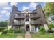 Three-story condo building with wooden balconies and well-manicured landscaping at 8135 Cedar Glen Dr, Charlotte, NC 28212