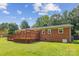 The brick home is complemented by a spacious backyard, wooden deck, and mature trees at 8706 Richardson King Rd, Waxhaw, NC 28173