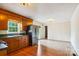Cozy kitchen with wood cabinets, stainless steel refrigerator, and view into an adjacent dining area at 8706 Richardson King Rd, Waxhaw, NC 28173