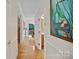 Hallway with hardwood floors leading to a dining room and bathroom with a painting on the wall at 8918 Beach Bluff Ct, Sherrills Ford, NC 28673