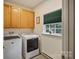 Functional laundry room with updated appliances, storage cabinets and natural light from a window at 8918 Beach Bluff Ct, Sherrills Ford, NC 28673