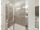 Modern bathroom with a glass-enclosed shower featuring gray tile and a built-in bench at 11546 Red Rust Ln, Charlotte, NC 28277