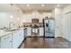 Beautiful kitchen with stainless steel appliances, wooden floors, white cabinets, and stone countertops at 11546 Red Rust Ln, Charlotte, NC 28277
