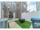 Back patio features brick exterior, a sliding glass door, and small faux grass area at 11546 Red Rust Ln, Charlotte, NC 28277