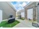 Side patio features neutral siding, faux grass, and a utility door into the home at 11546 Red Rust Ln, Charlotte, NC 28277