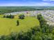 Expansive aerial view of a suburban neighborhood, showcasing a spacious green field and well-maintained homes at 117 Carmine Ct, Troutman, NC 28166