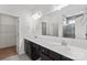 Bright bathroom featuring double sinks, a large mirror, and a glimpse into a tiled shower at 117 Carmine Ct, Troutman, NC 28166