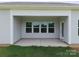 Covered patio featuring a concrete slab, multiple windows, and a door leading to the home's interior at 117 Carmine Ct, Troutman, NC 28166