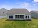 Rear exterior of the home with a covered patio and well-maintained lawn, complemented by nearby houses at 117 Carmine Ct, Troutman, NC 28166