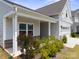 Inviting front porch featuring brick accents, landscaping, and gray vinyl siding at 117 Carmine Ct, Troutman, NC 28166