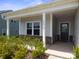 Welcoming front porch with a gray door and siding and manicured landscaping at 117 Carmine Ct, Troutman, NC 28166