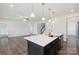 Open concept kitchen with island overlooking the living area, and stairs to the second floor at 117 Carmine Ct, Troutman, NC 28166